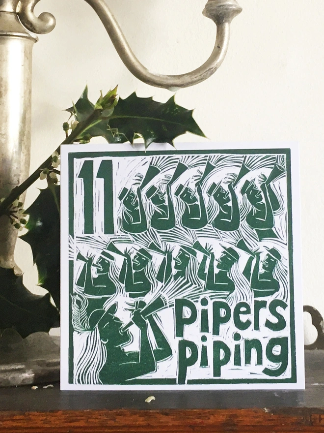 Christmas card Nine Pipers Piping The Twelve Days of Christmas linocut design by Kate Guy