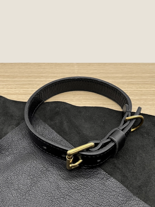 black leather dog collar on wood and leather prop