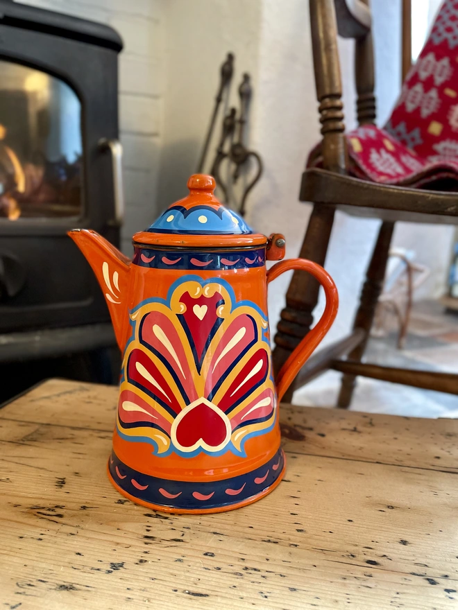 Orange vintage coffee pot, hand painted with a fairground inspired design in pink, red, orange, yellow and blue.