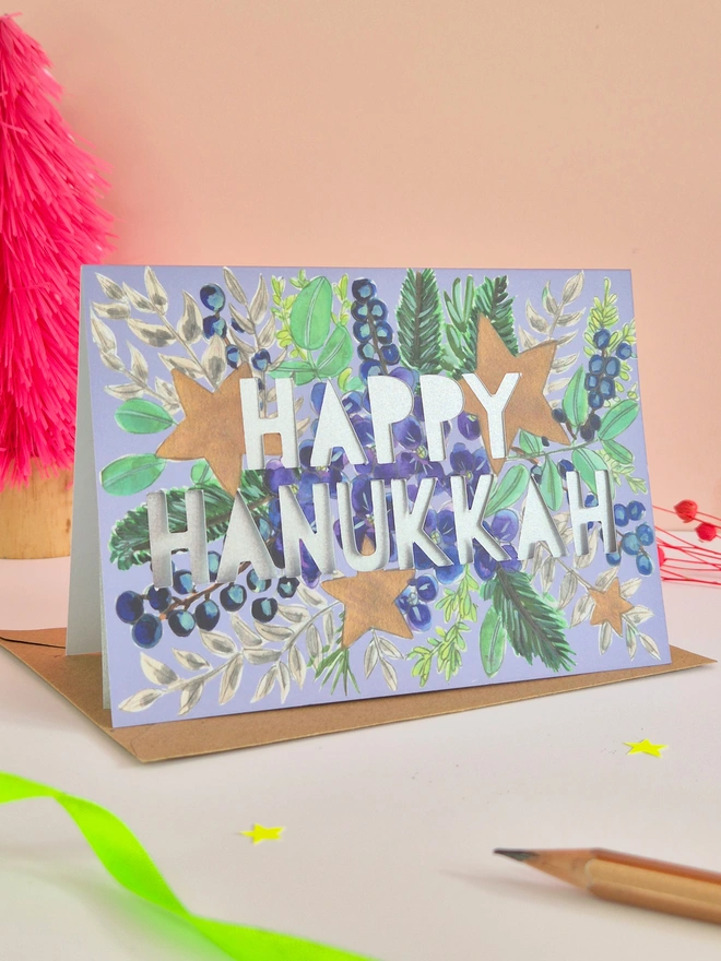 Hanukkah card with blue hydrangea, stars and paper cut text with a metallic silver backing paper 
