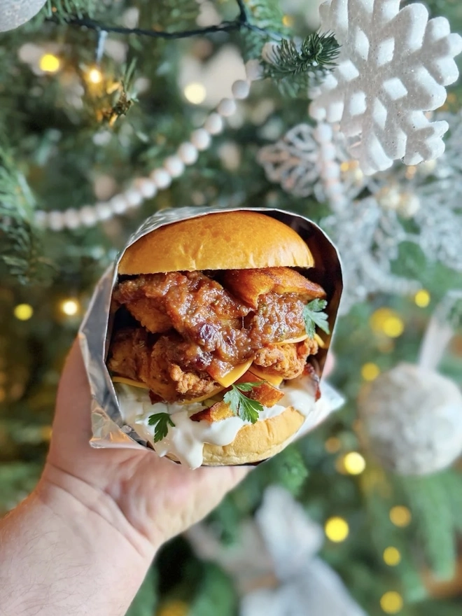 Smoked Bacon & Maple Jam (Set Of 1, 2 Or 3), a burger being held by a person with a bit of the jam smeared inside. 