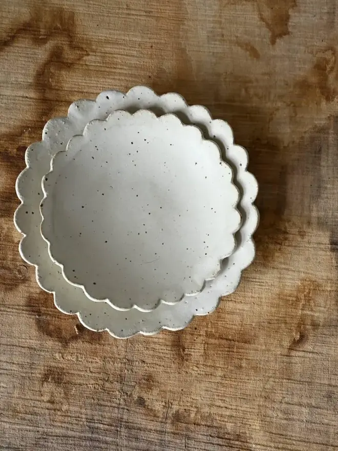 Handmade Scalloped Ceramic Dish, a pair of ceramic dishes on a wooden surface. 