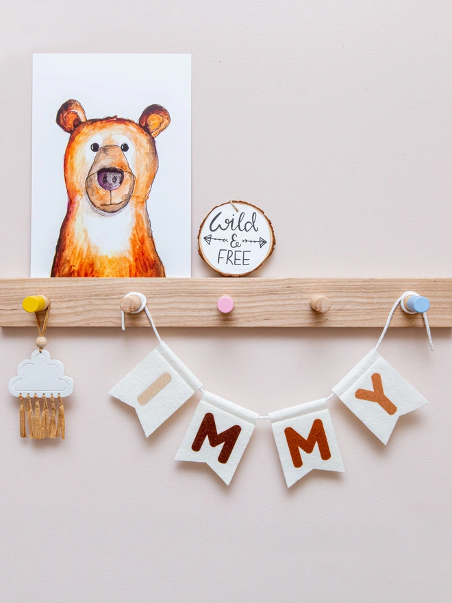 Personalised childrens bunting. The text is a mix of neutral brown colours on white felt flags.