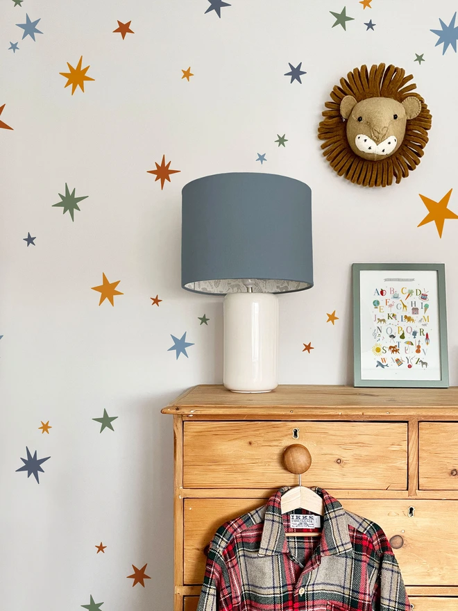 Ducks In A Row Warm Winter Star Wall Stickers in boys bedroom with Lion Head, Drawers and lamp