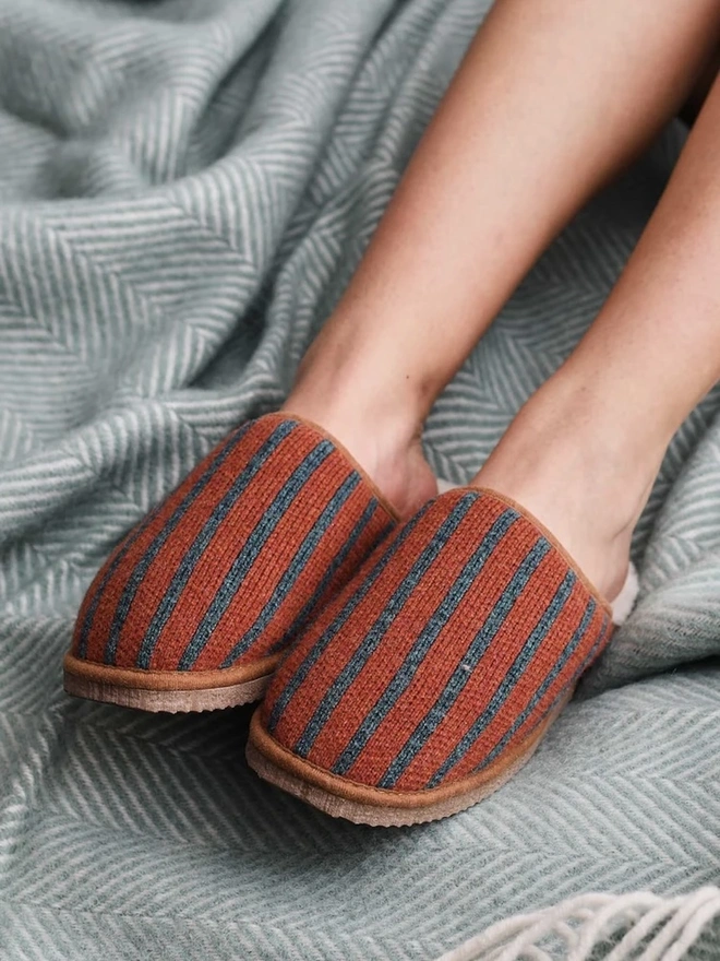 Women's Lambswool & Sheepskin Slippers, a person wearing a pair of colourful slippers indoors. 