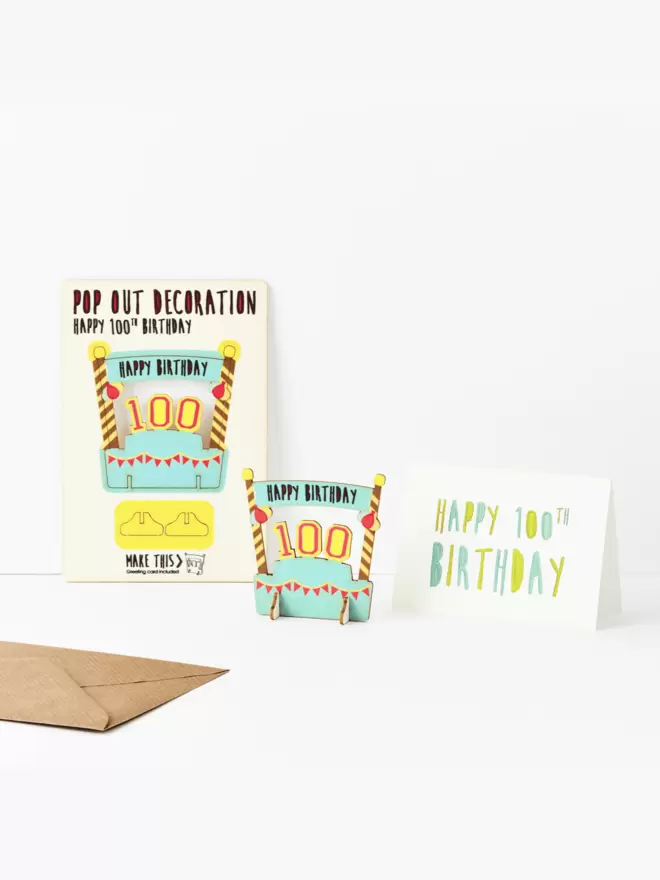 One hundredth birthday decoration and one hundredth birthday card and brown kraft envelope on a white background