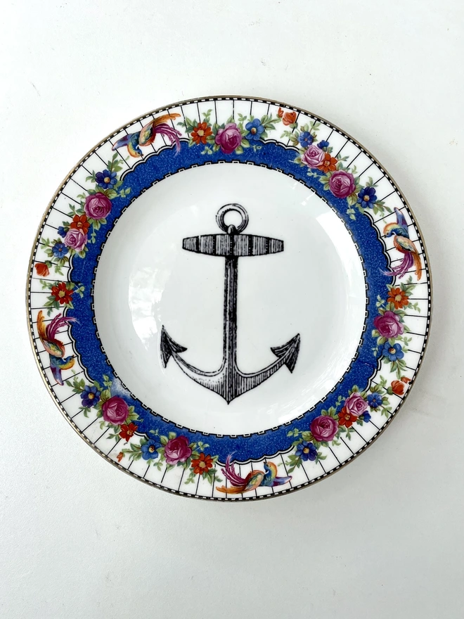 vintage plate with an ornate border, with a printed vintage illustration of an ship's anchor in the middle 