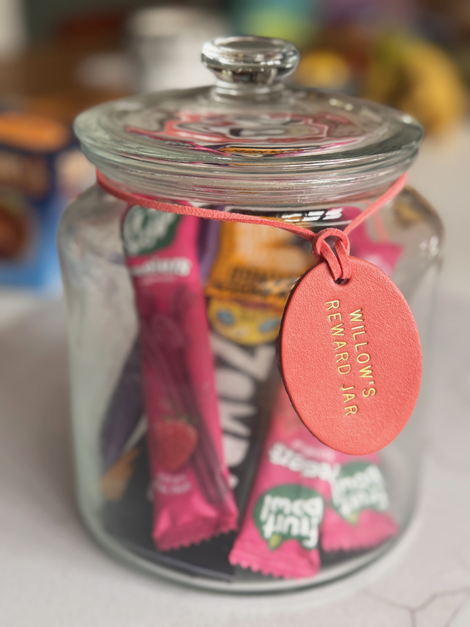 coral leather tag in an oval shape on a jar of treats