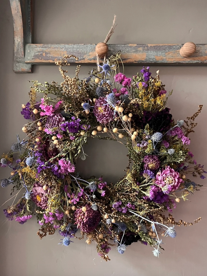 Colourful Autumnal Wreath. An autumnal wreath made of colourful, seasonal flowers, hung on a wall.