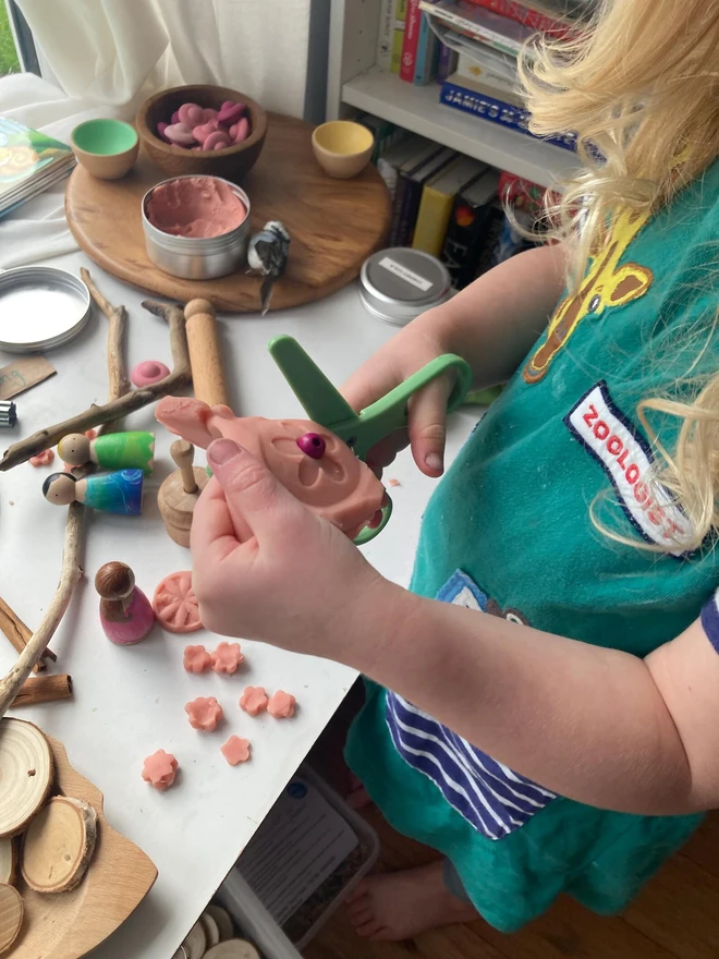 fairy sensory play dough sensory set. a child playing with dough and cutting it into different shapes.