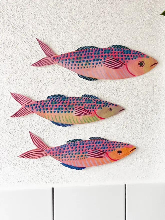wooden mackerel wall decoration. three mackerel decorations hung up on white wall