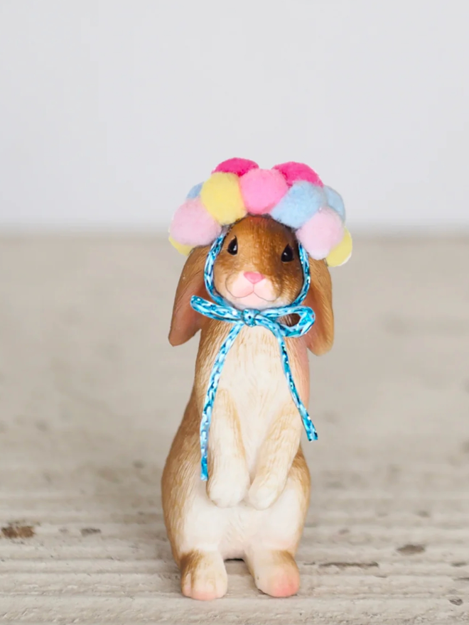 Rabbit with Pom Pom Headdress Cake Topper Decoration. A standing rabbit with a multicoloured pom pom hat.