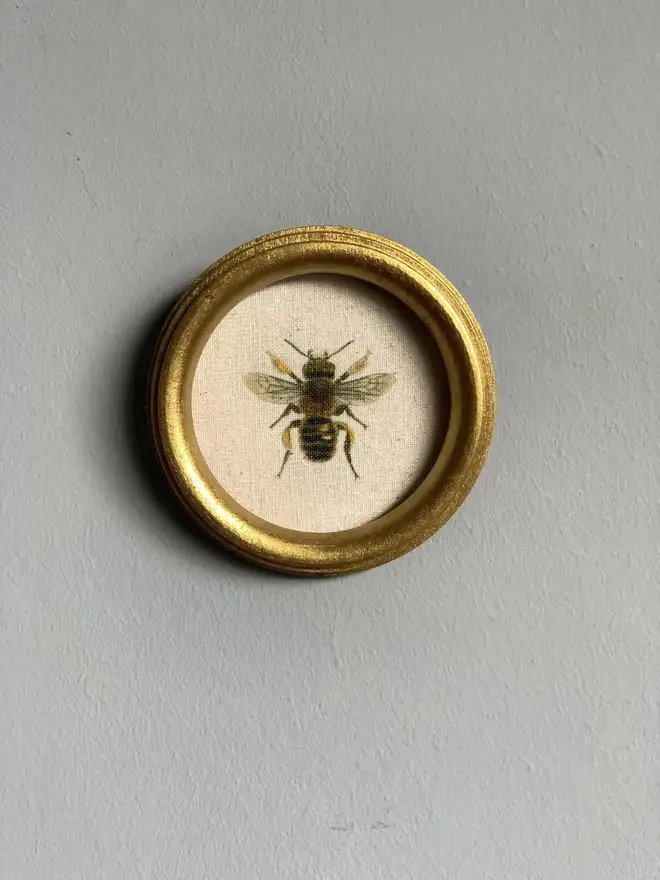 Round gold frame with mini bee print