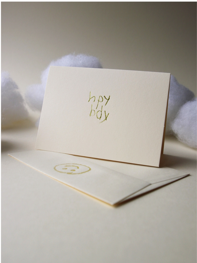 sandy coloured card with hpy bdy hand foiled in kids hand writing