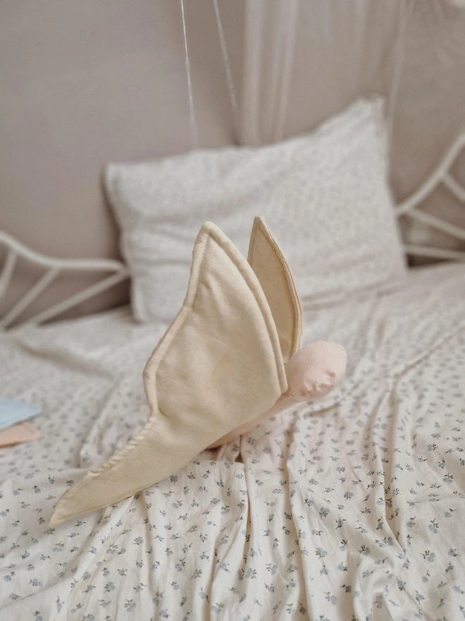Butterfly Nursery Decoration, a colourful butterfly decoration sitting on a child's bed. 