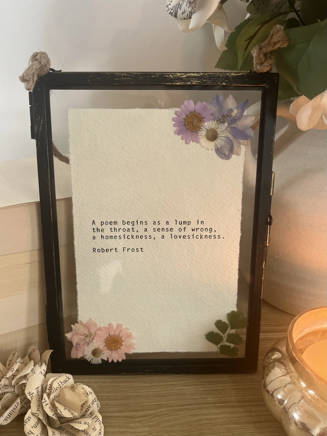 Robert Frost poem hand typed on a vintage typewriter onto cotton rag handmade deckled paper. The quote is frames in a black hanging rustic frame with gold brush detailing and displayed with real pressed dried flowers.