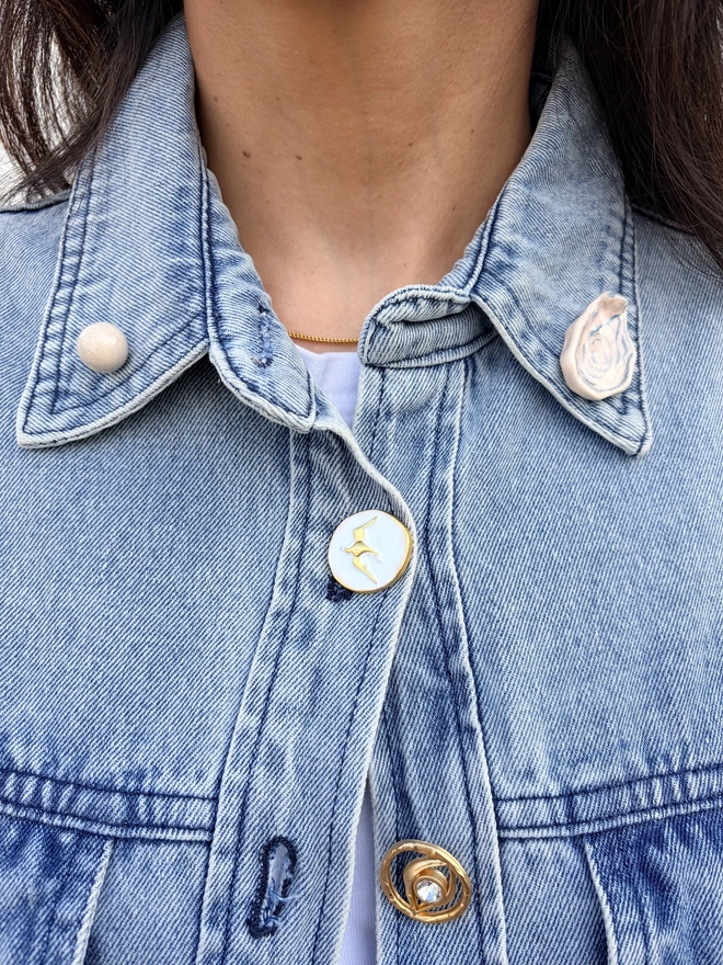 Foodie collar pins. An oyster and a pearl collar pin worn on the collars of a denim shirt