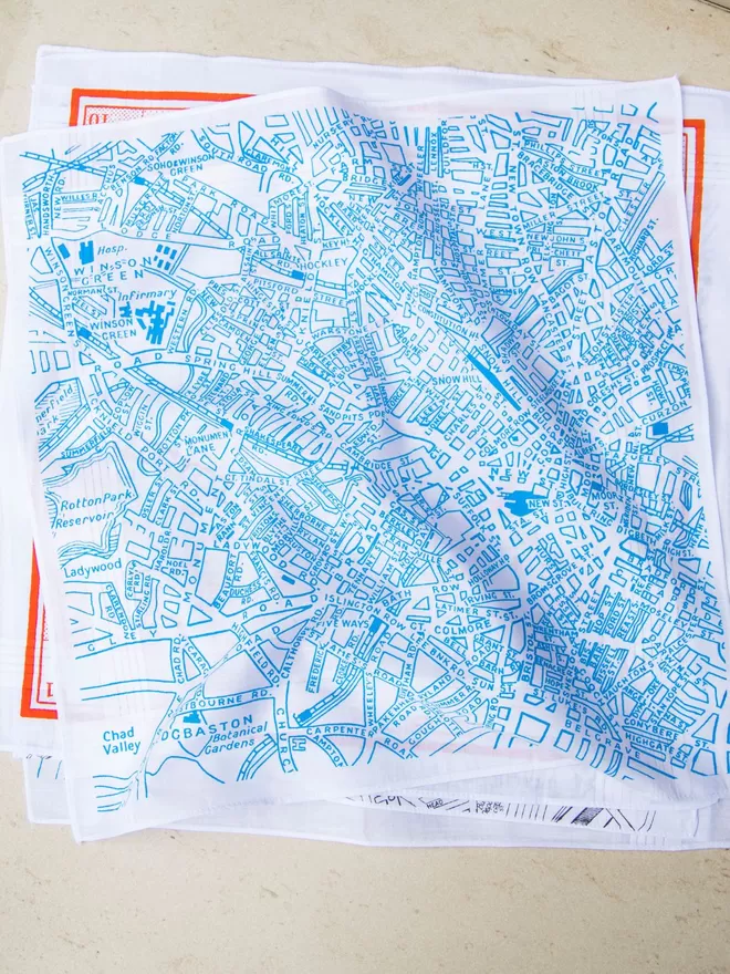 A pile of Mr.PS printed hankies with a Birmingham map hankie in sky blue on top.