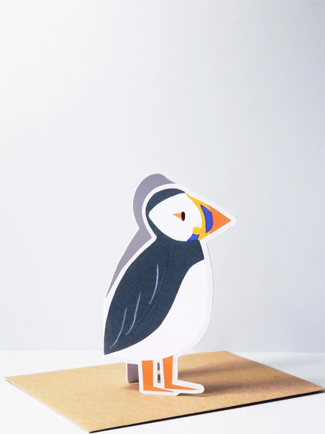 A cut out card of a puffin on top of an envelope