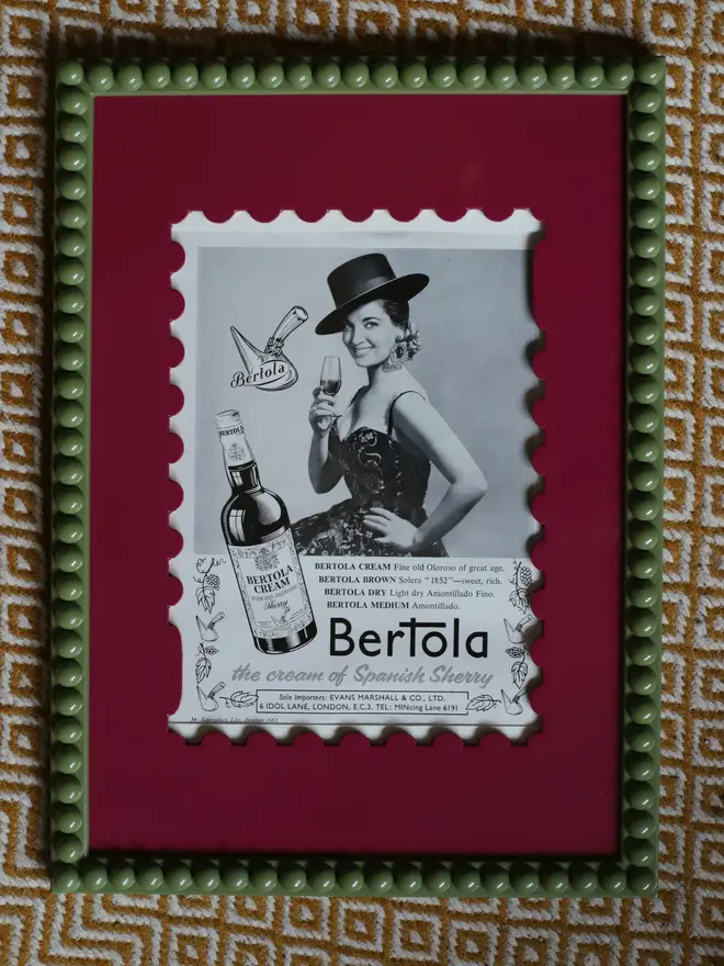 orchid pink stamp shaped frame mount with green bobbin frame and black and white picture