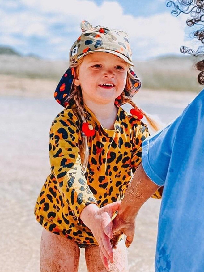 Girl wearing sun baseball hat in leopard neutral print