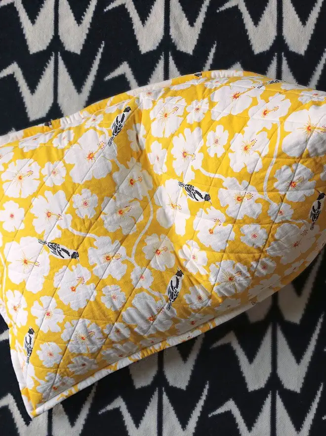 Crane Flatweave Rug, a colourful rug sitting in a living room. It is accompanied by other colourful items. 