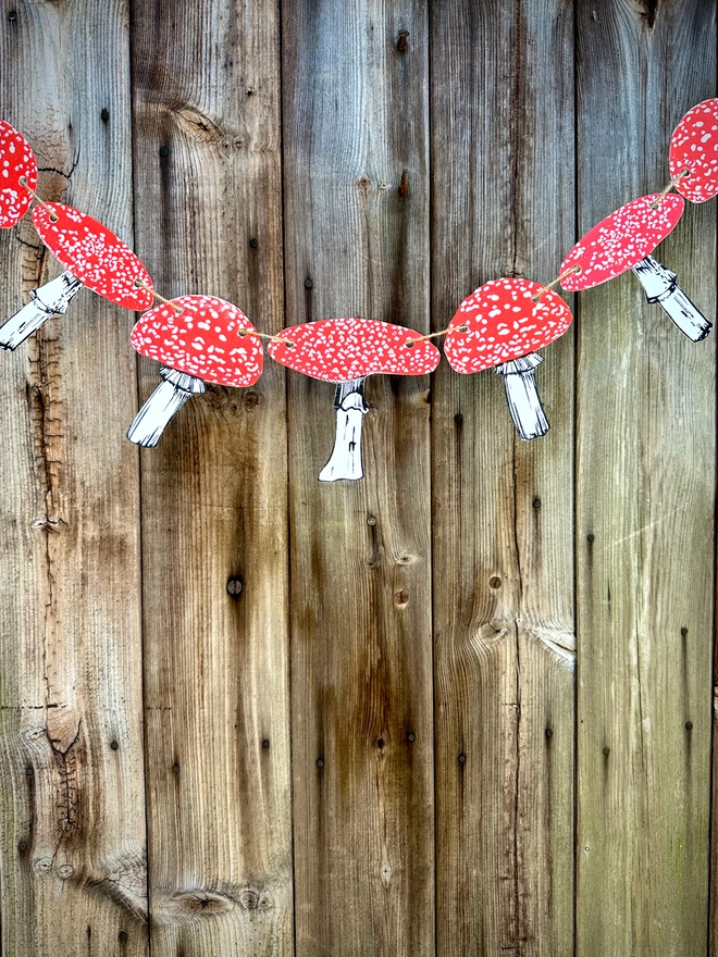 Fly Agaric Mushrooms, 9 hand printed fungi on a bunting string.Linocut parts, movable red black and white ink.