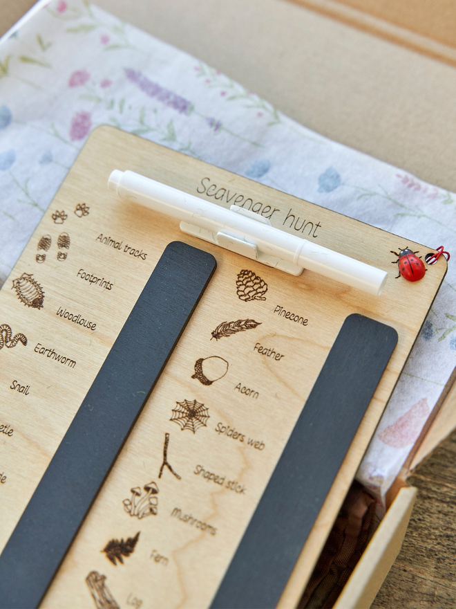 A wooden scavenger board hunt with a white pen 