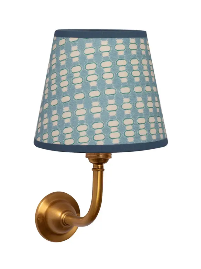 blue lalli patterned lampshade on golden sconce, on white background
