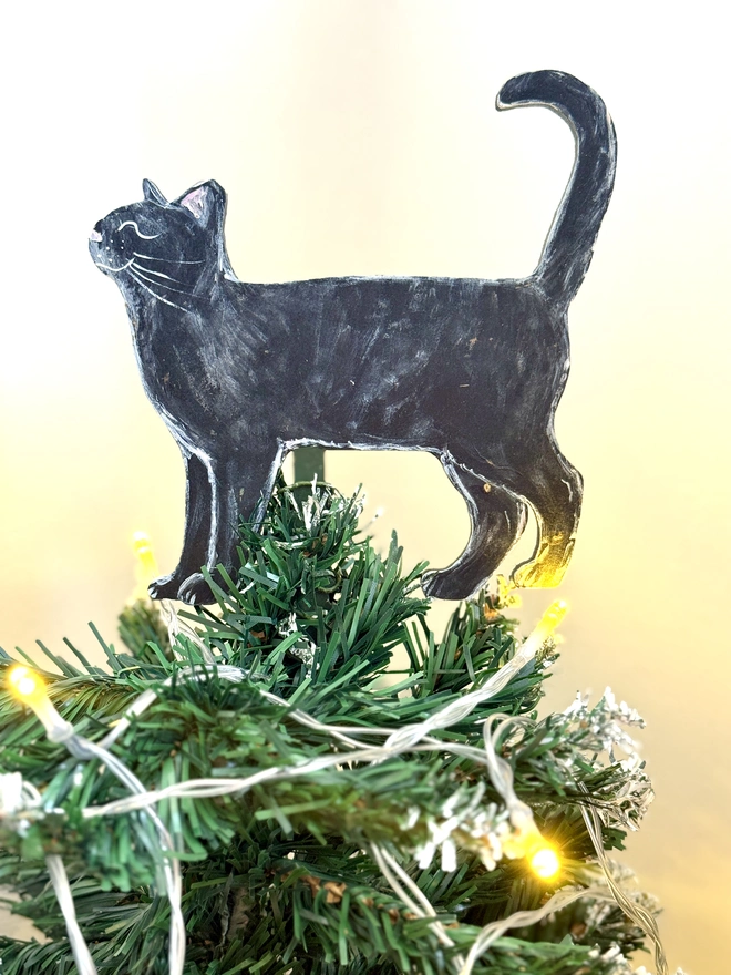 Black cat Christmas Tree Topper placed at the top of a Christmas tree 