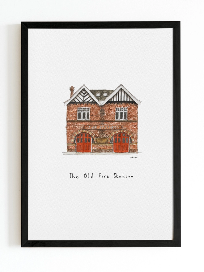 Beautiful watercolour illustration of The Old Fire Station in Tonbridge.  A brick building with two red framed arched double doors. The watercolour style is painted with a black pen outline and organic loose style with small details.  The print is on white background with black frame around.