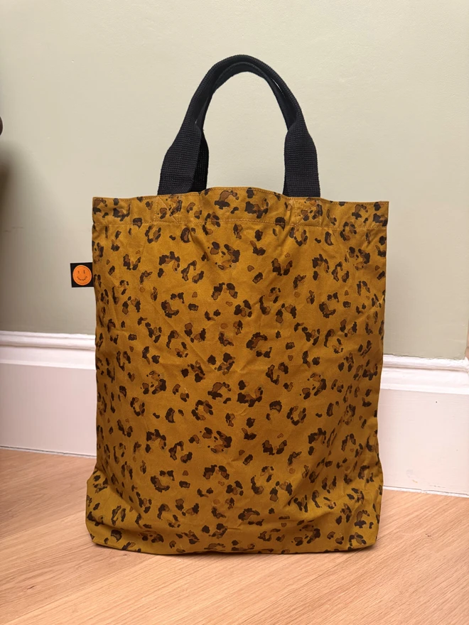 leopard bag on floor in front of green wall