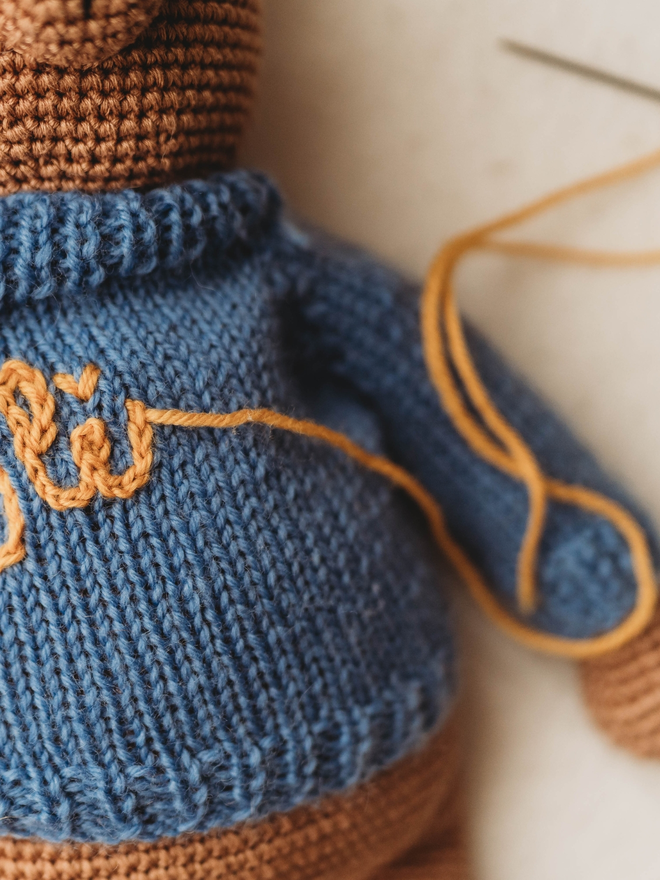 hand crochet brown teddy bear with blue hand knit jumper close up