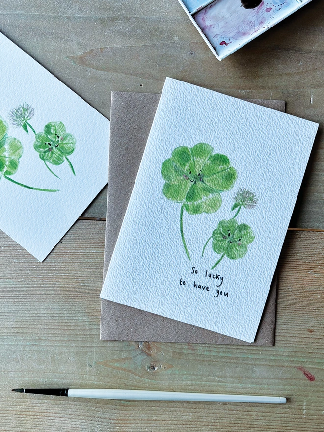 Lucky to have you, Four Leaf Clover Greeting Card featuring a watercolour illustration of a large and small four leaf clover the card reads 'So lucky to have you'