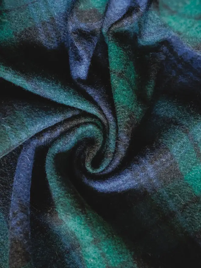 Black Watch Tartan Blanket, a green blanket curled up. 