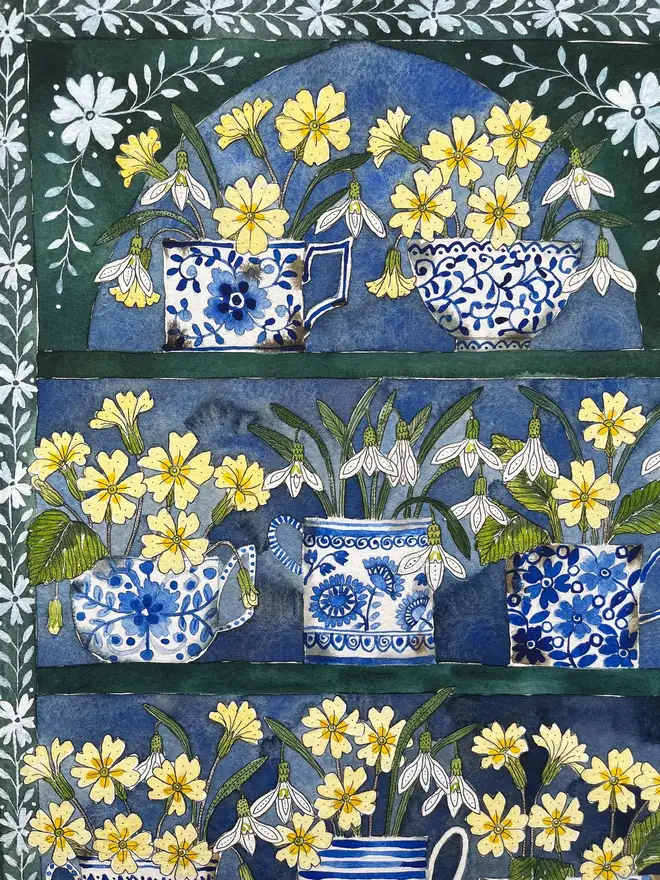Snowdrops and primroses in delftware, ceramic mugs displayed in a plant Theatre print