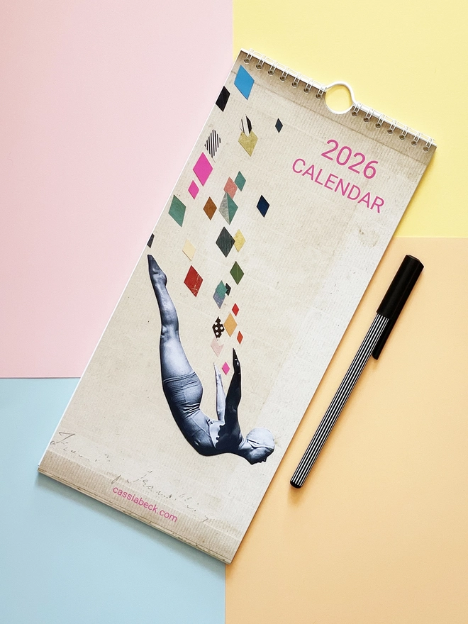 A slim wall calendar against a colourful background.