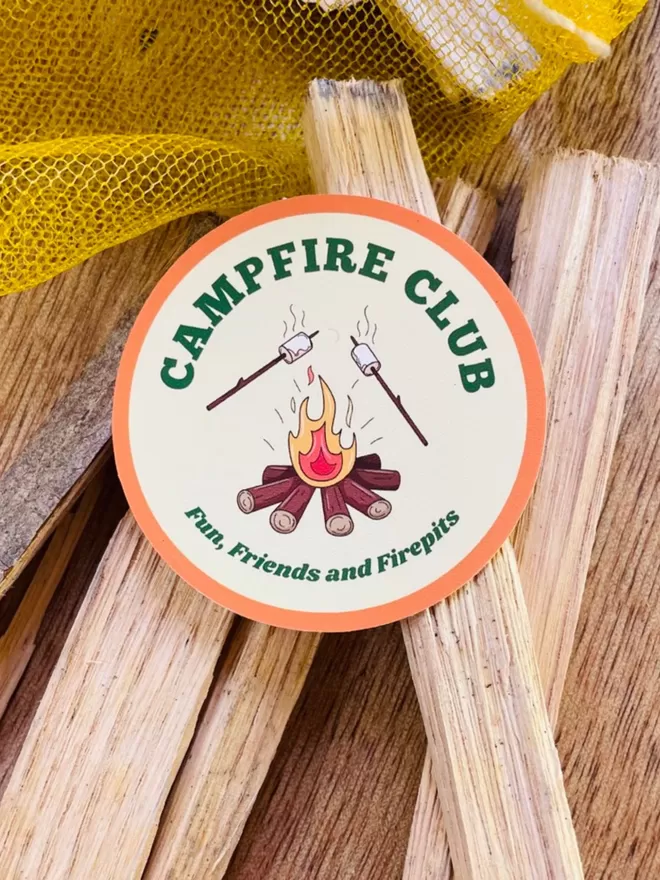 Campfire Club Vinyl Sticker on some firewood.