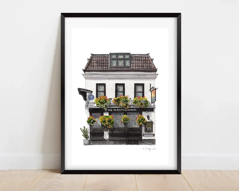 Rotherhithe The Mayflower Pub Giclée Print (Unframed), a print of a pub sitting in a black frame against a wooden surface against a plain backdrop. 