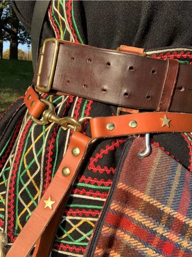 Tan leather dog lead with brass stars worn as a belt!