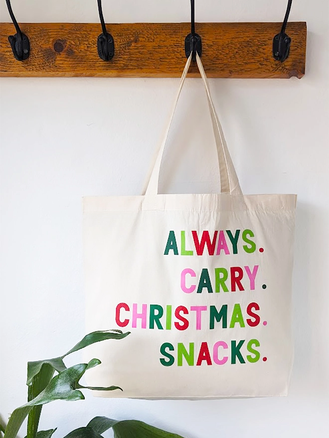 A natural coloured tote bag with 'Always Carry Christmas Snacks' slogan