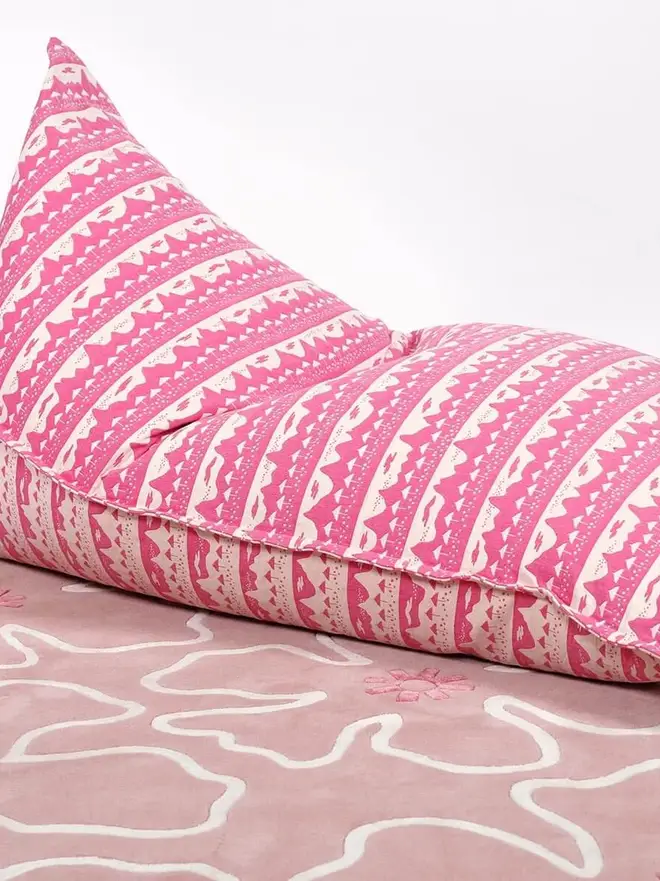 Pink Belle Mare Woven Bean Bag Cover, a pink bean bag sitting against a white backdrop on a decorated floor. 