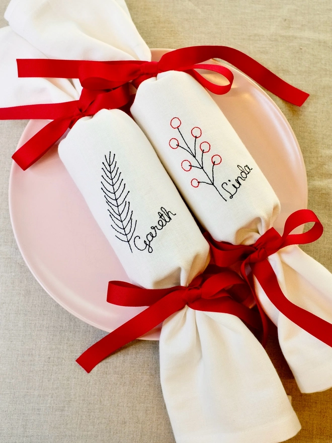 Personalised embroidered fabric Christmas cracker napkins fir and berries and red ribbon bows 