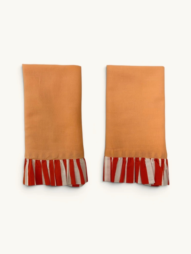 Pair of Ruffle Napkins. A pair of napkins, folded, in peach and tangerine.