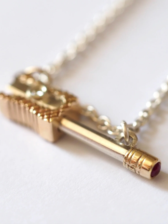 Pencil & Sharpener Necklace. A gold pencil and sharpener necklace.