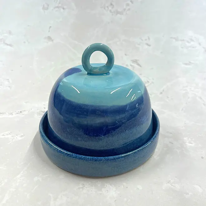 Landscape Butter Dish, a colourful butter dish sitting on a stone surface. In the image the lid sits on top of the dish. 