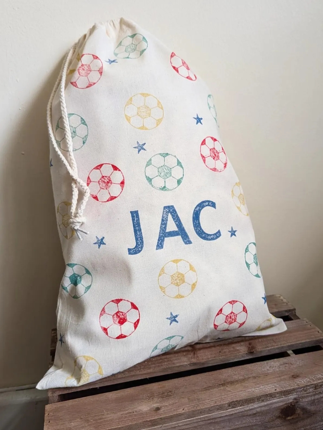 personalised football bag. a drawstring bag with printed footballs and a personalised name.