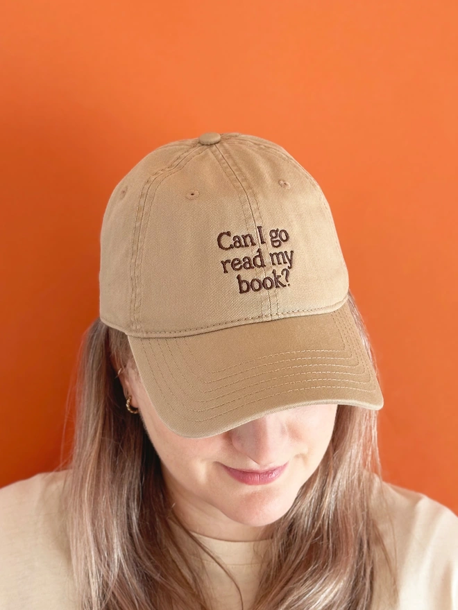 'Can I Go Read My Book?' Cotton Baseball Cap beige being worn by a woman
