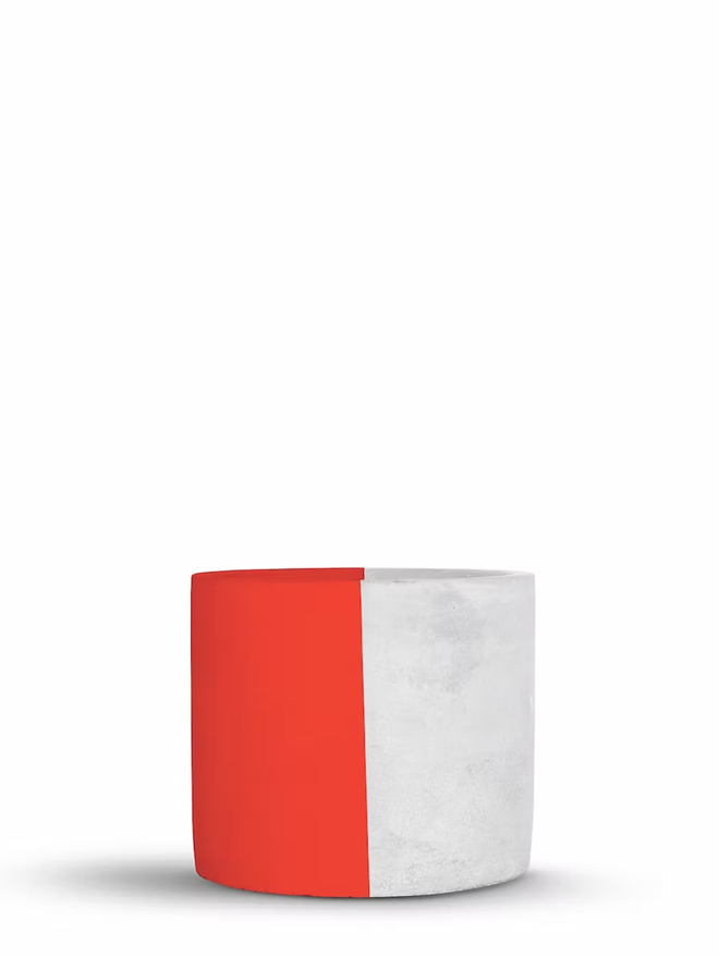 half & half concrete plant pot. a grey concrete plant pot painted half red.