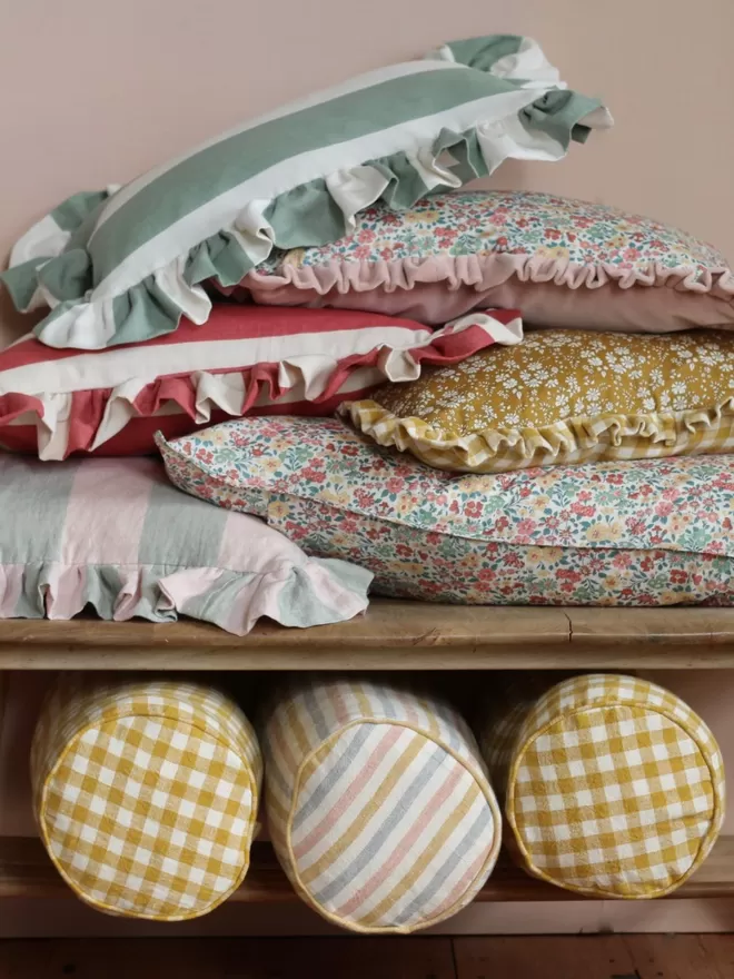 Linen Bolster Cushion 'Seaside Stripe' mid shot of the cushion displayed with other cushions 